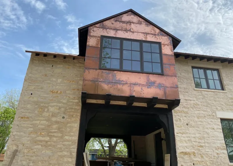 Copper metal panel facade on a stone building for Roof Repair in Almont