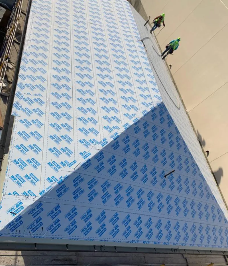 Professional roofers installing underlayment on a metal roof in Almont